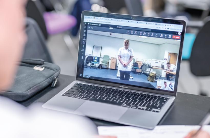 Photo of a clinician in front of a computer which is showing a person standing of our simulation feature