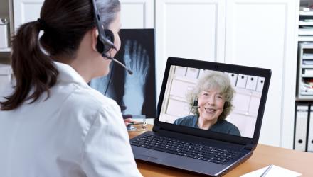 healthcare professional having a computer consultation with a patient