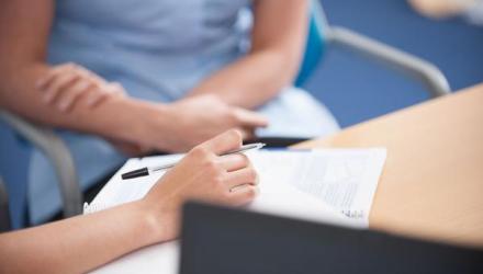 a physiotherapist making notes in a notepad