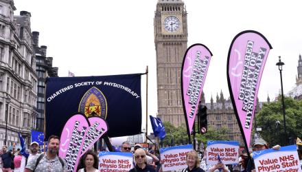 marchers hold CSP banners in front of Big Ben